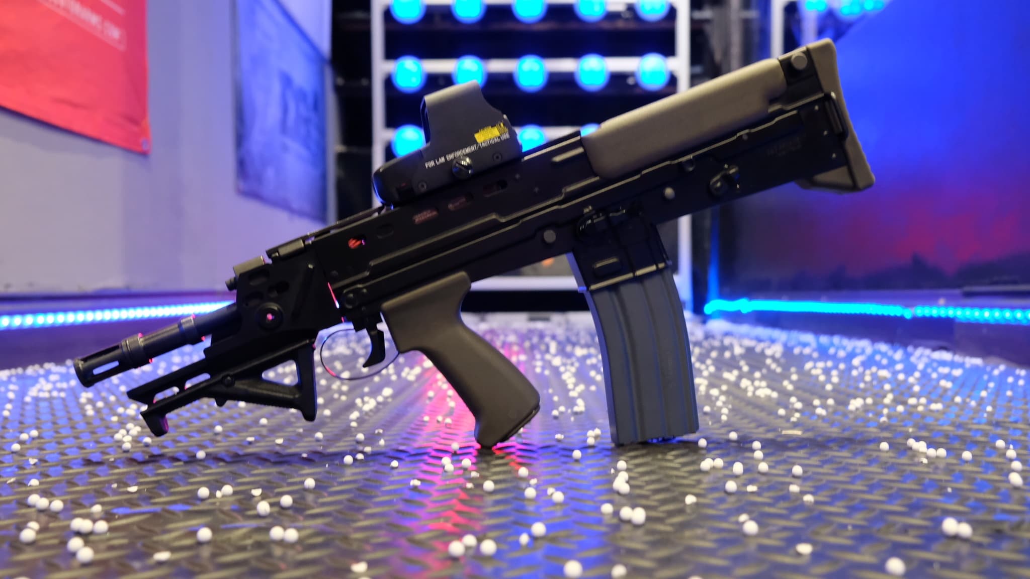 Compact submachine-style airsoft rifle on illuminated range table