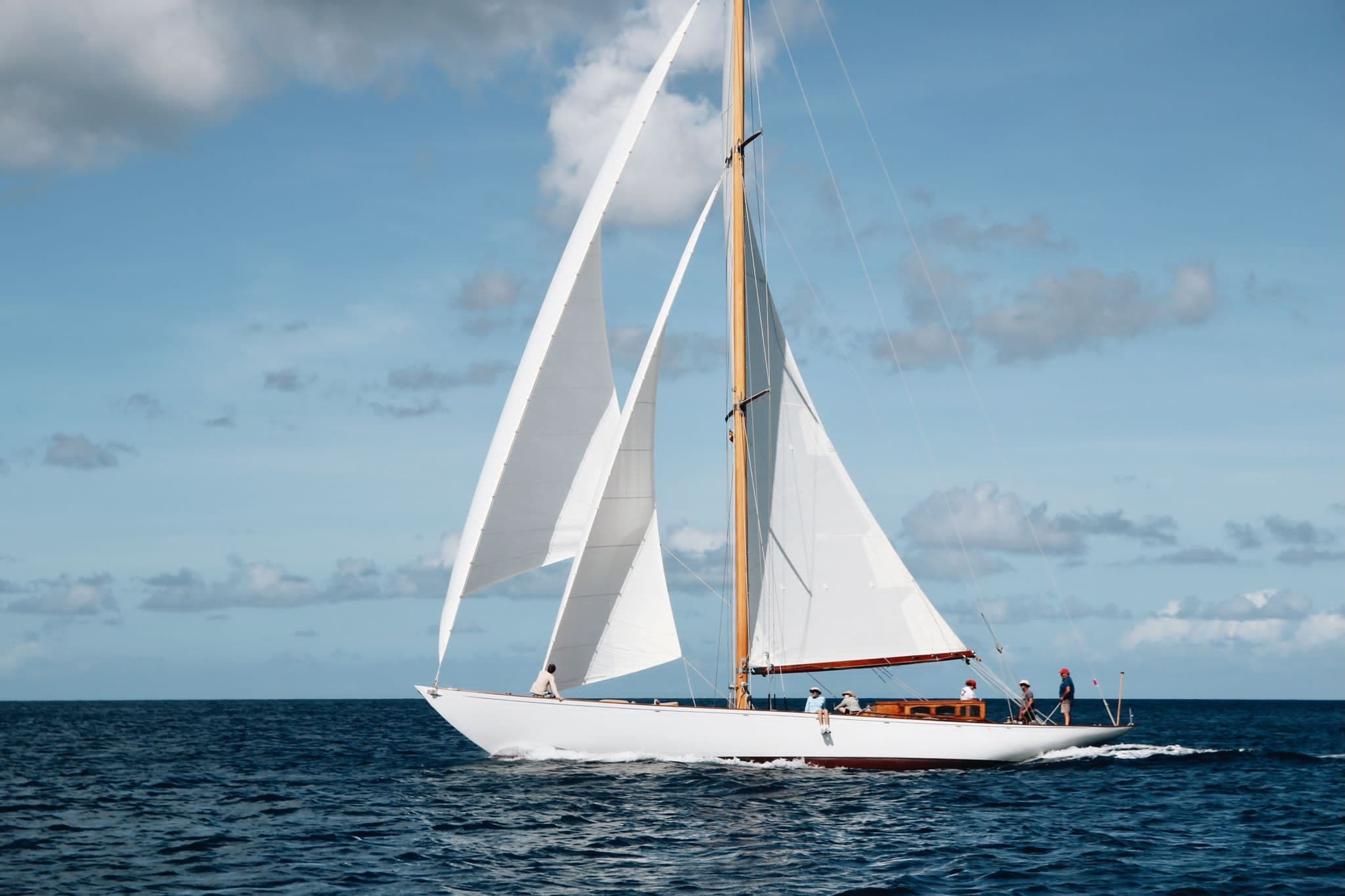 Classic sailing yacht cruising on open blue ocean under sky