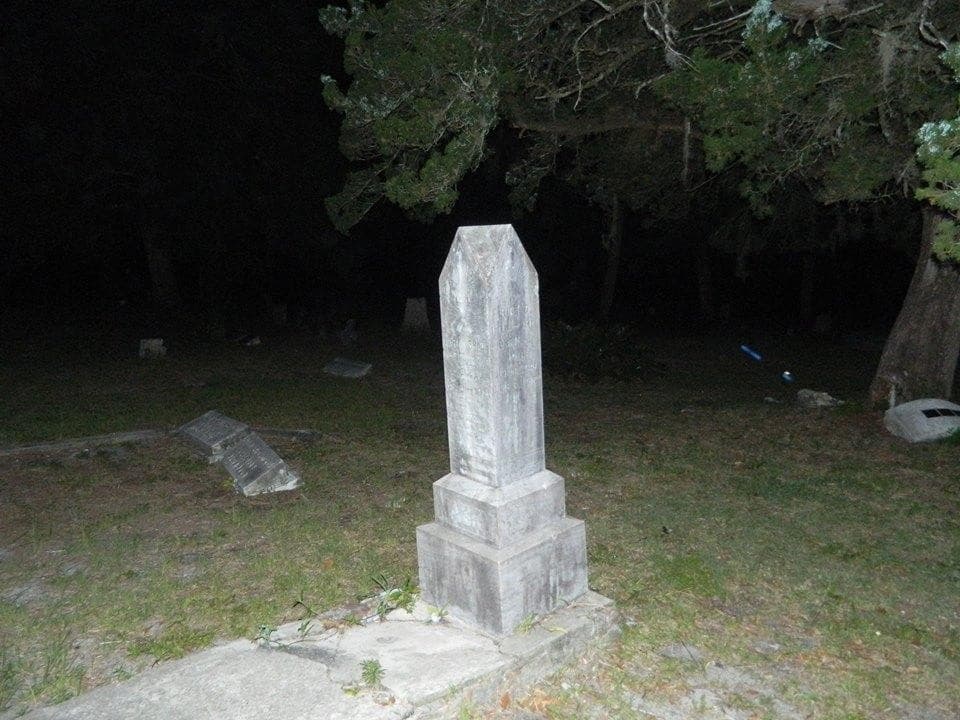 Historic cemetery tombstone at night on St. Augustine tour