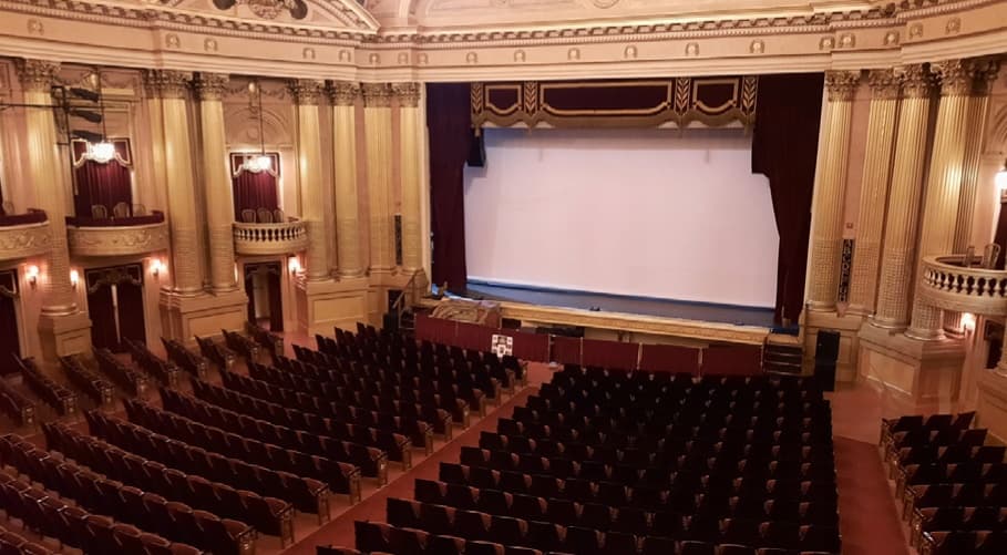 Ornate historic theater auditorium interior, stage ready for performance