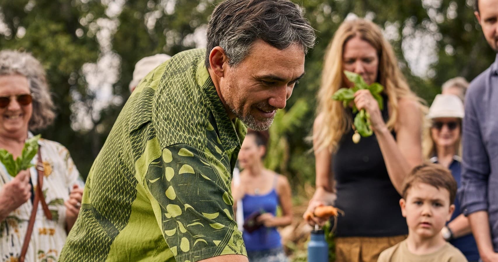 Outdoor community cooking demonstration at garden gathering