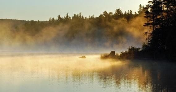 Misty sunrise over Lake of Two Rivers with calm reflective water