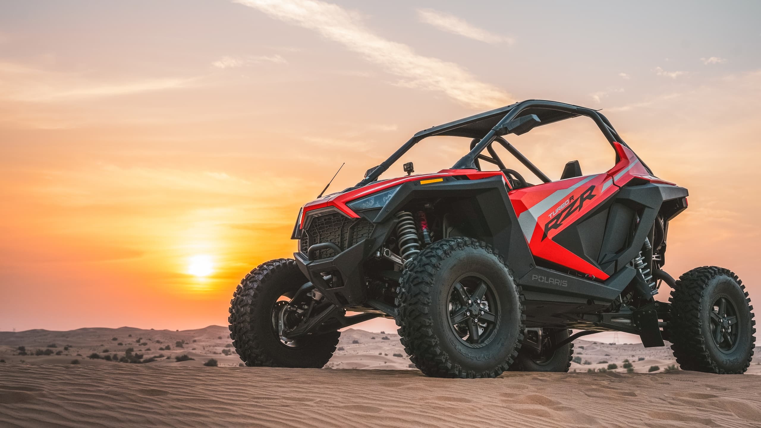 Rider on ATV pointing from dune top in Dubai desert