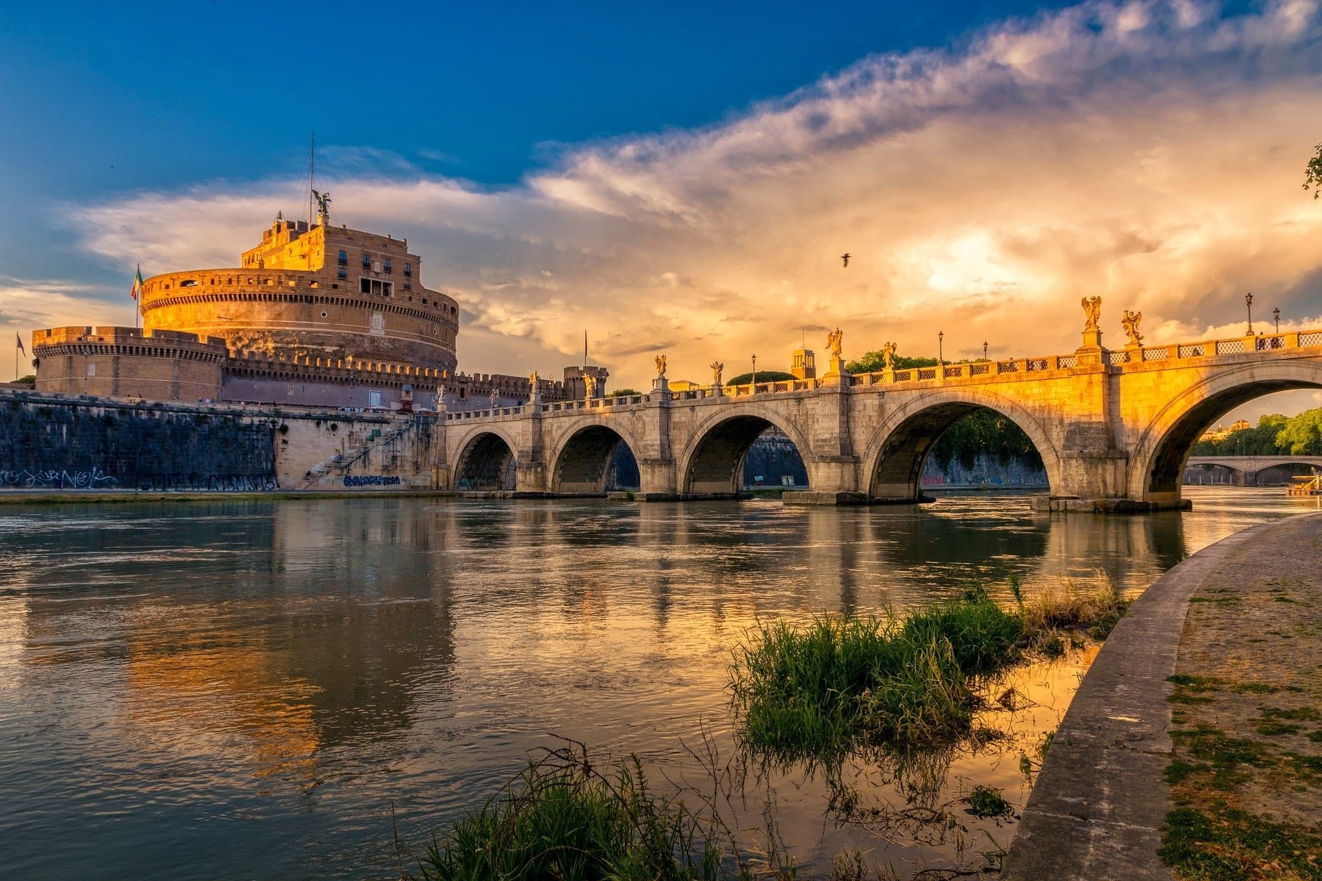 Tiber River bridge with Castel Sant'Angelo at golden hour in Rome