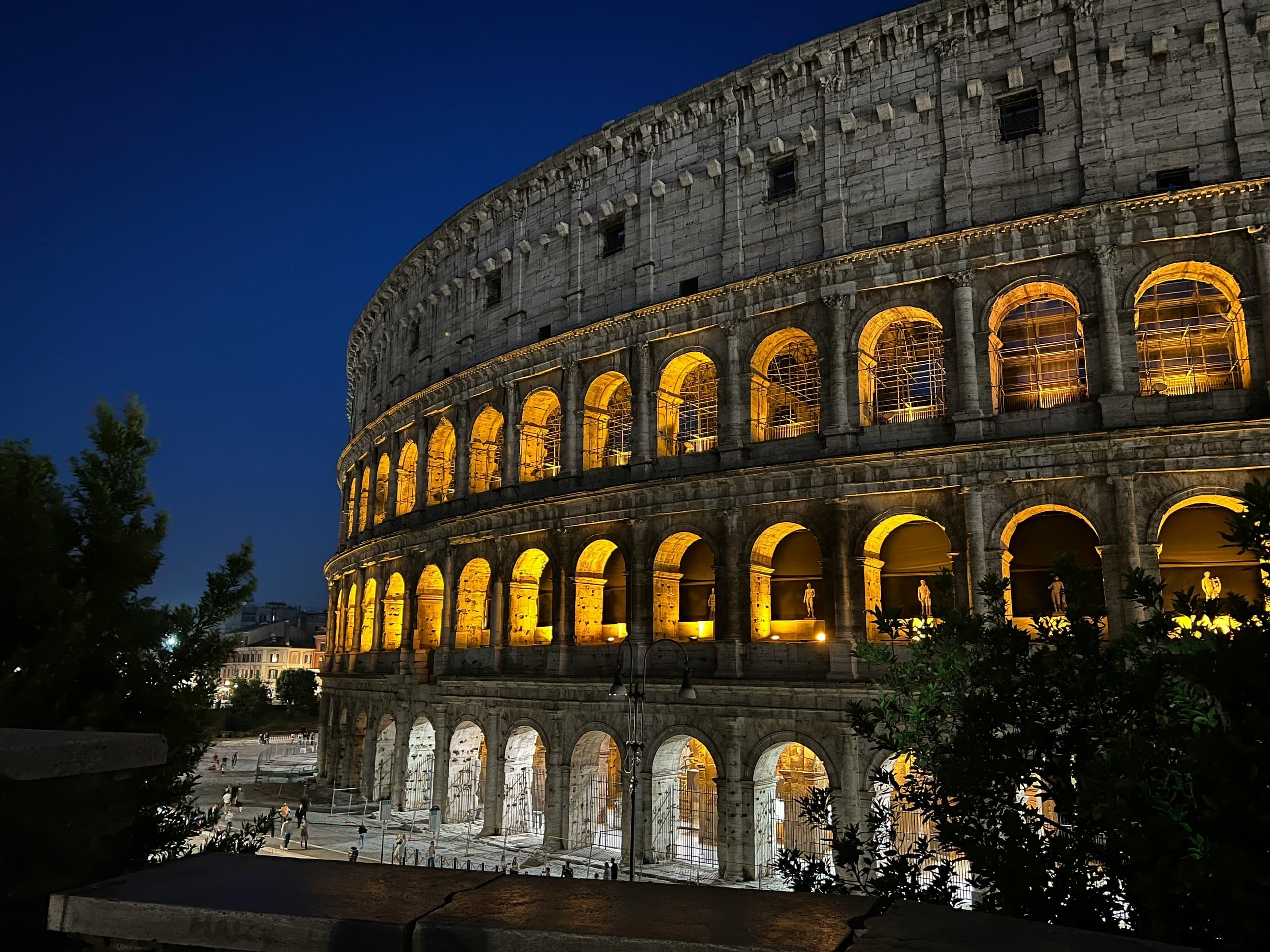 Nighttime Colosseum illuminated in Rome, historic exterior view