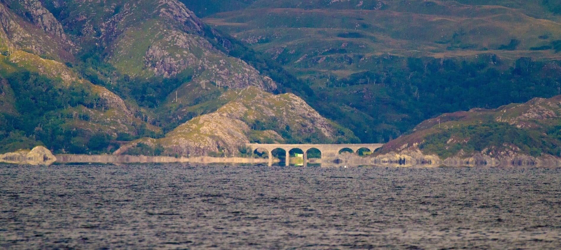 Scenic coastal arch and sea view with distant hills at Arisaig