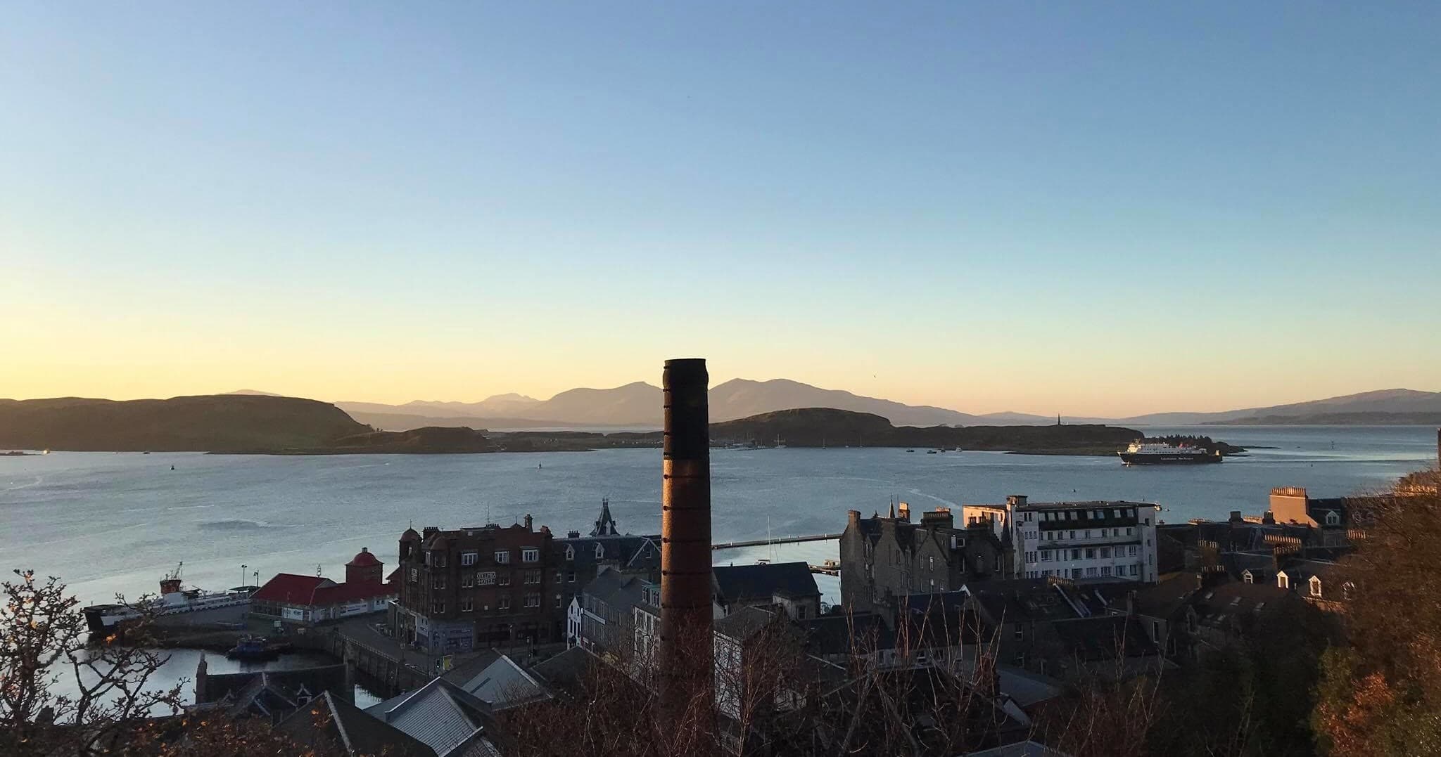 Panoramic coastal view over Oban harbor at sunset