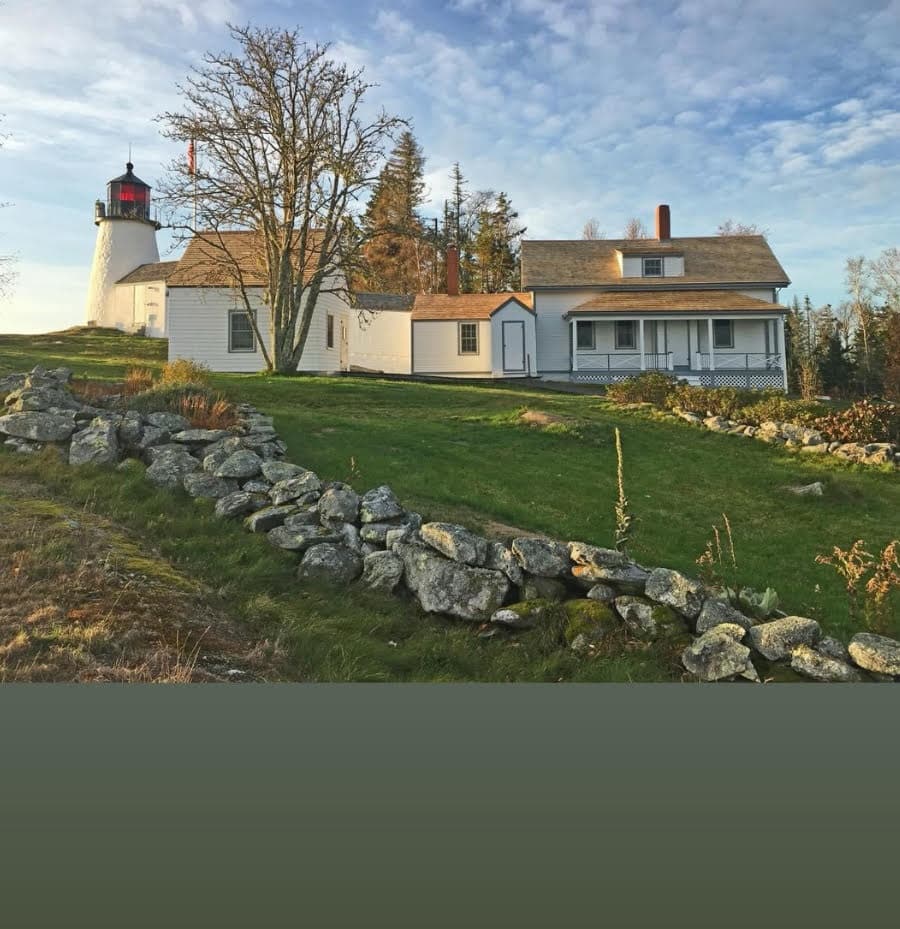 Lighthouse and keeper's house on grassy rocky coastline
