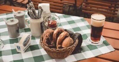 Artisan bread and beer served outdoors at a rustic beer garden table