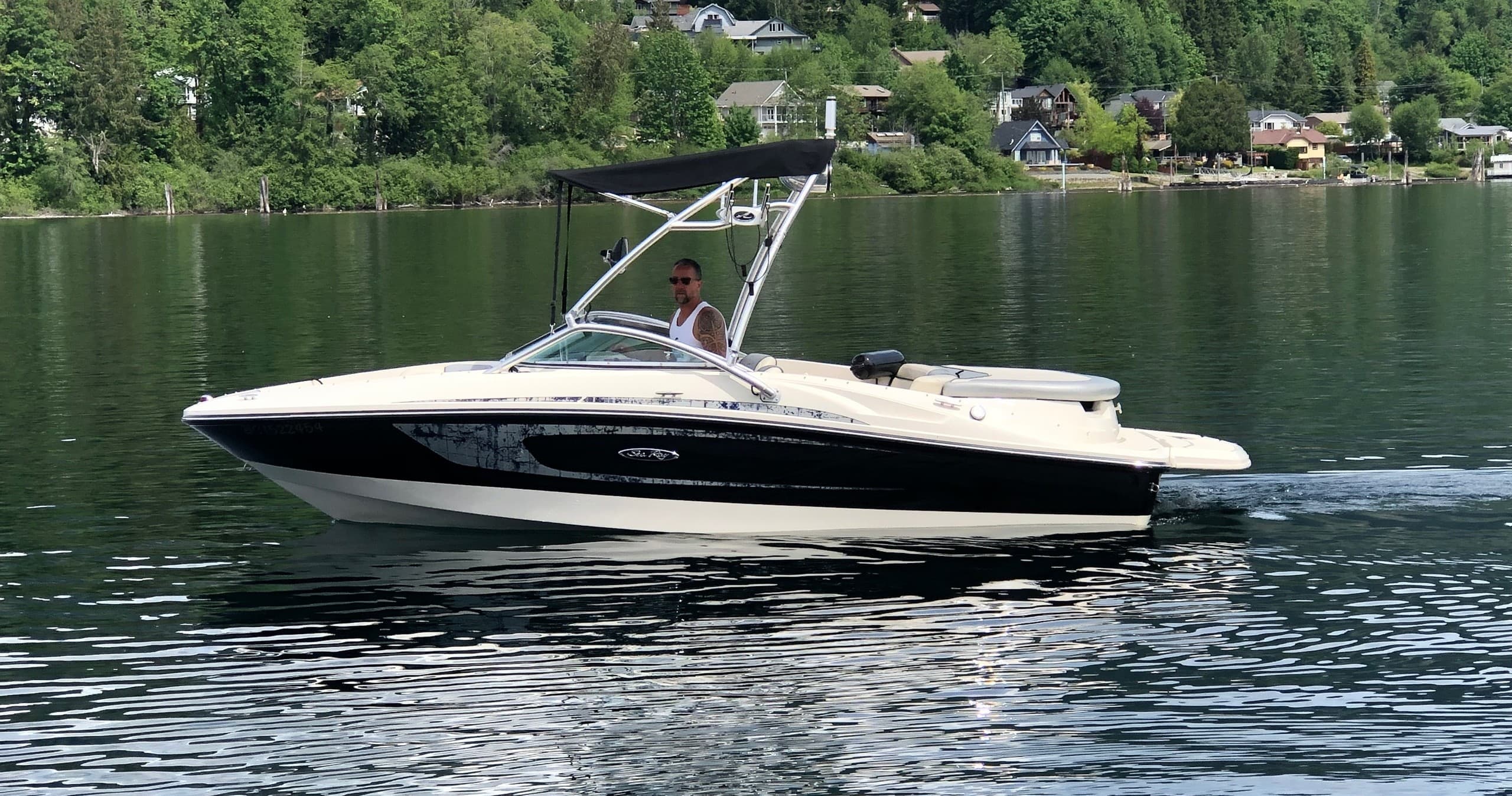 Motorboat cruising on Cowichan Lake shoreline, scenic summer ride