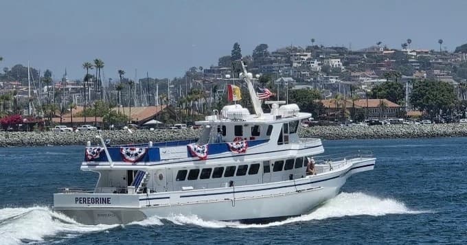 Sightseeing yacht cruising San Diego coastline at speed