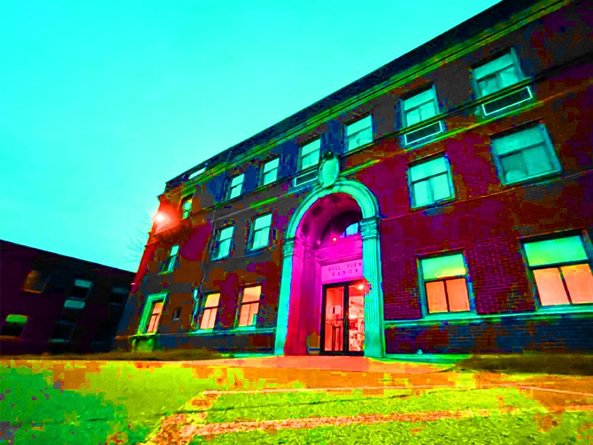 Victorian manor exterior with dramatic colored night lighting