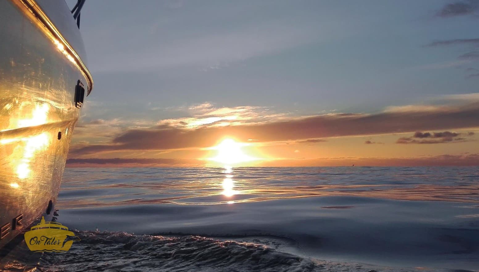Sunset cruise with boat hull reflecting golden light on calm sea