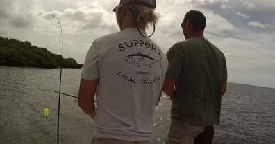 Anglers fishing from small boat in coastal estuary waters