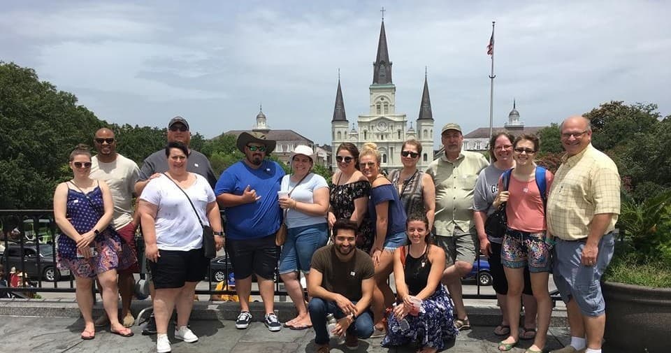 Group tour posing in front of St. Louis Cathedral in New Orleans