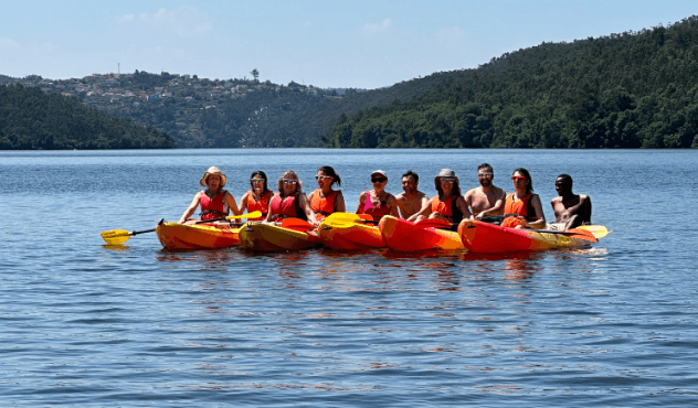 Group kayakers paddling on a scenic lake with forested hills