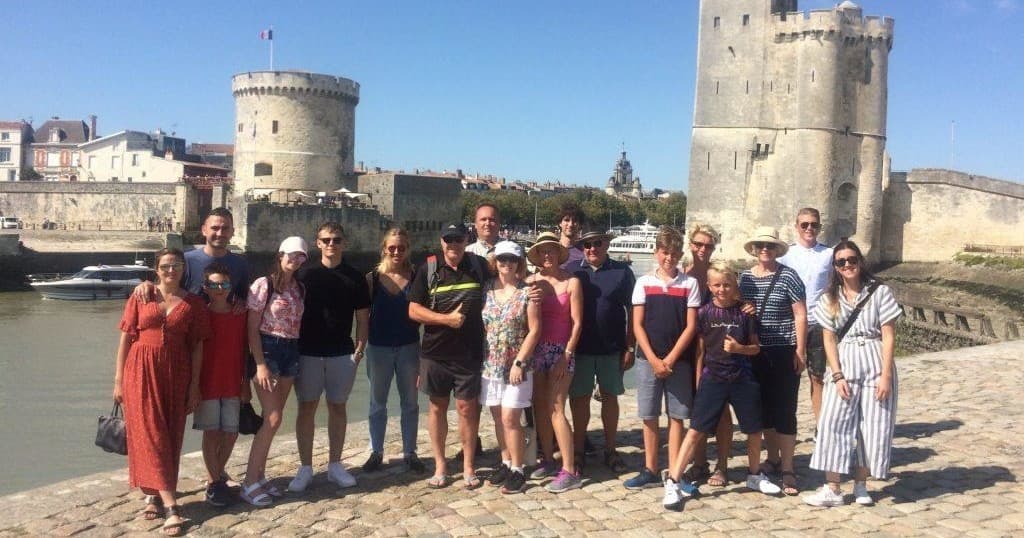 Guided walking group at La Rochelle harborfront by medieval towers