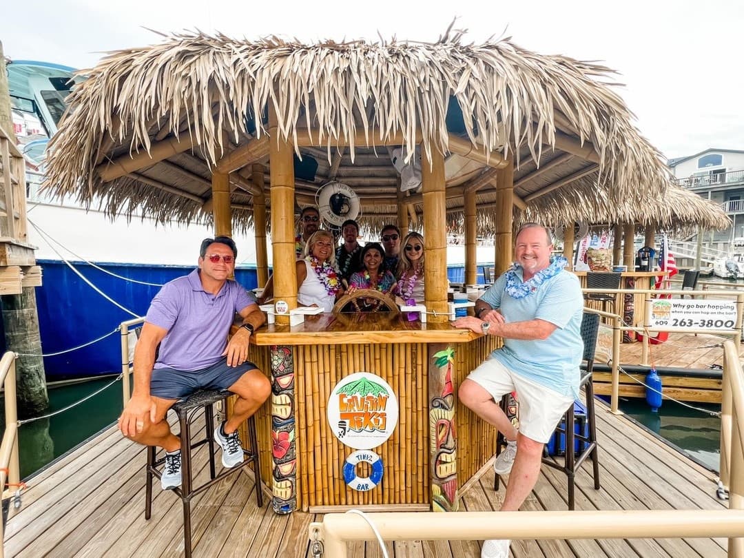 Tiki bar boat at marina with passengers enjoying daytime cruise