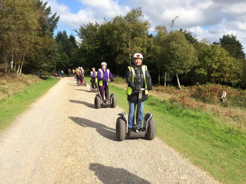 Segway riders touring forest trail at Cann Woods in Devon