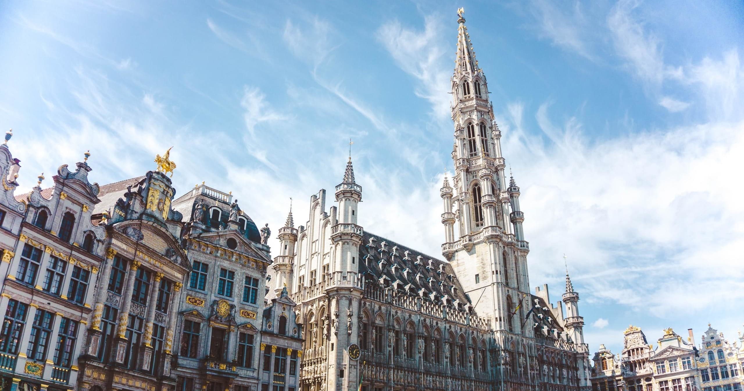 Ornate European guildhall facades under blue sky at historic square