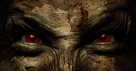 Close-up monstrous face with glowing red eyes in ruins