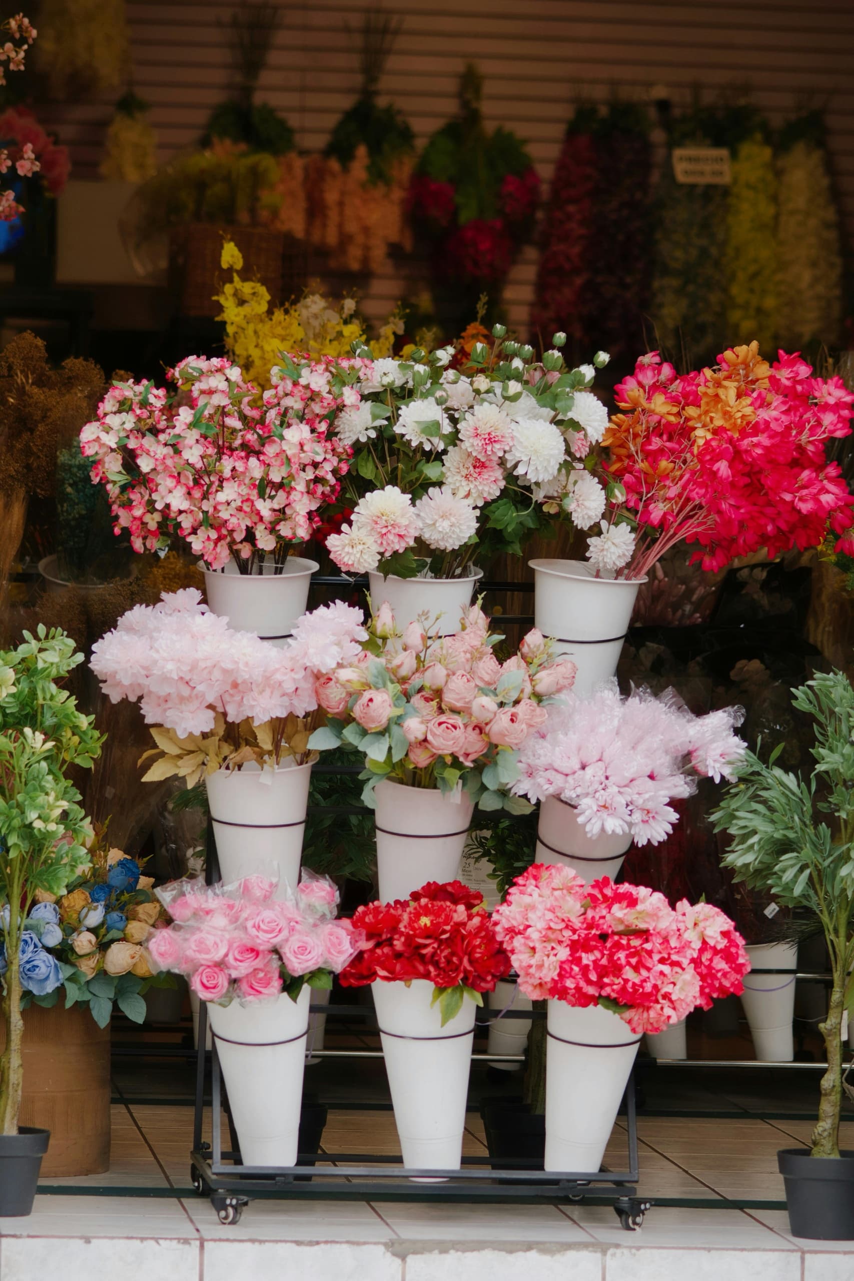 Outdoor flower market display with assorted potted blooms at shopfront