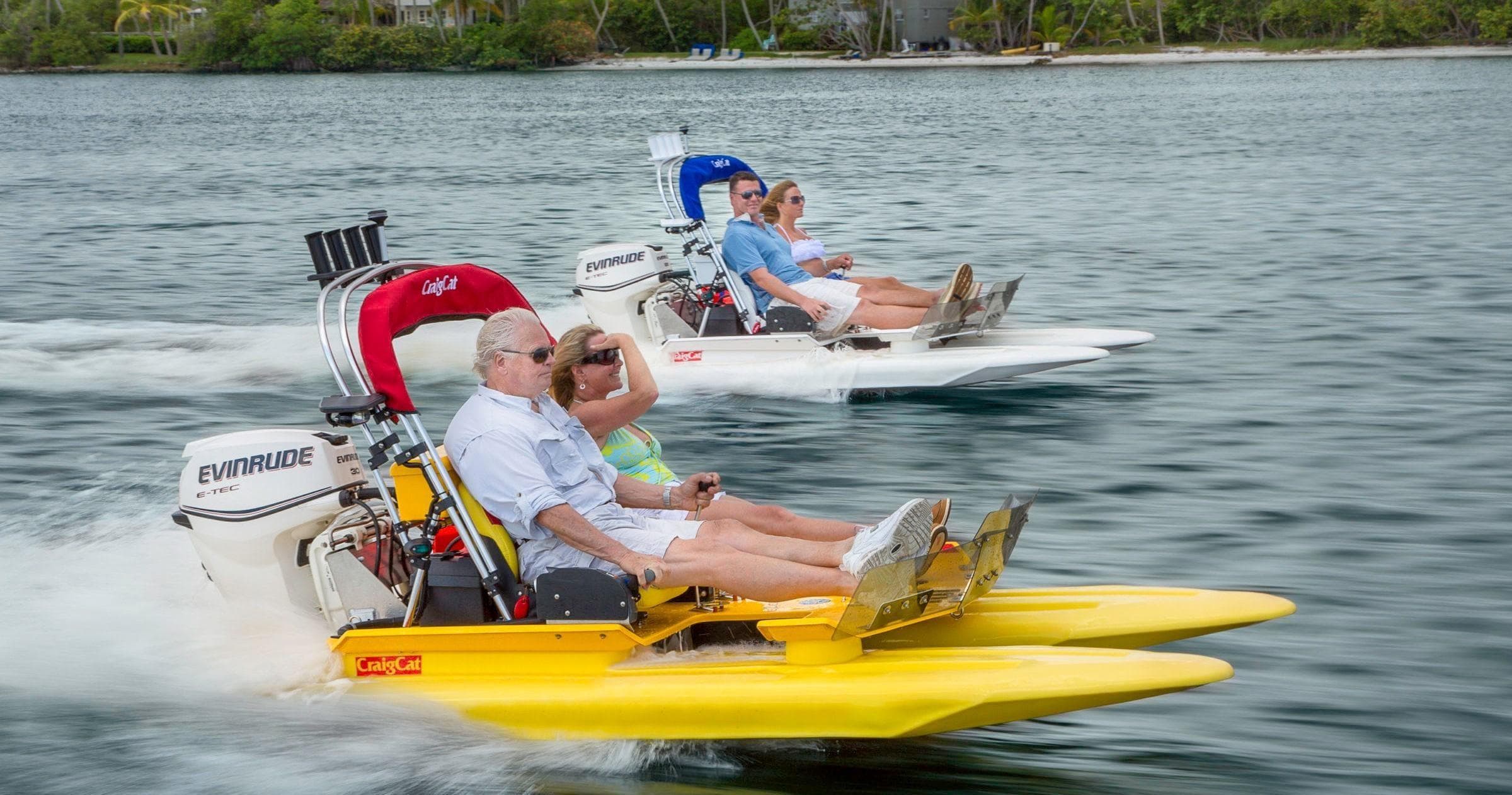 Two pontoon-style watercraft speeding along sheltered coastal water