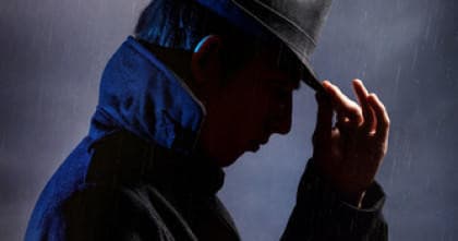 Silhouette of guide in rain suggesting eerie walking tour atmosphere