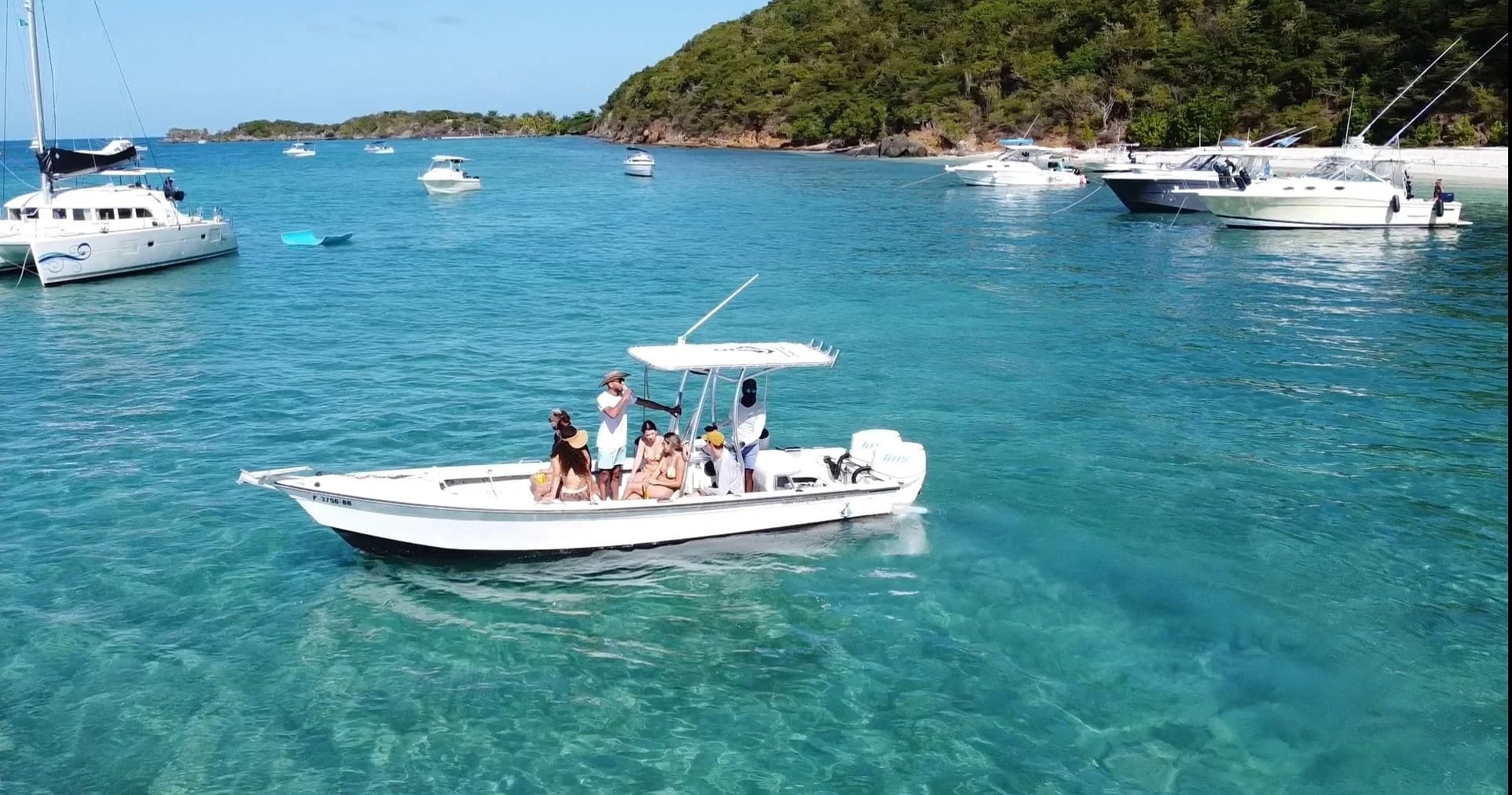Small motorboat cruising crystal clear Caribbean waters with guests