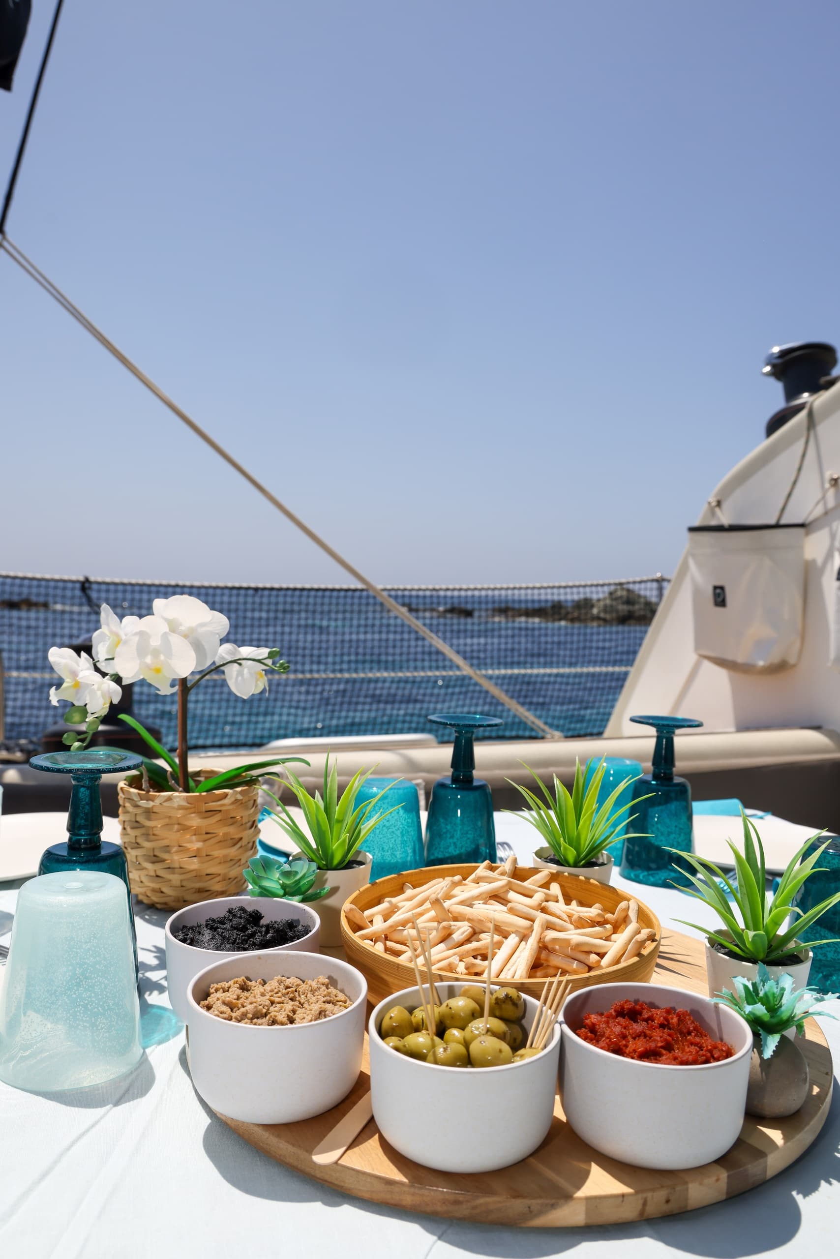 Close-up boat snack spread with olives and dips on deck