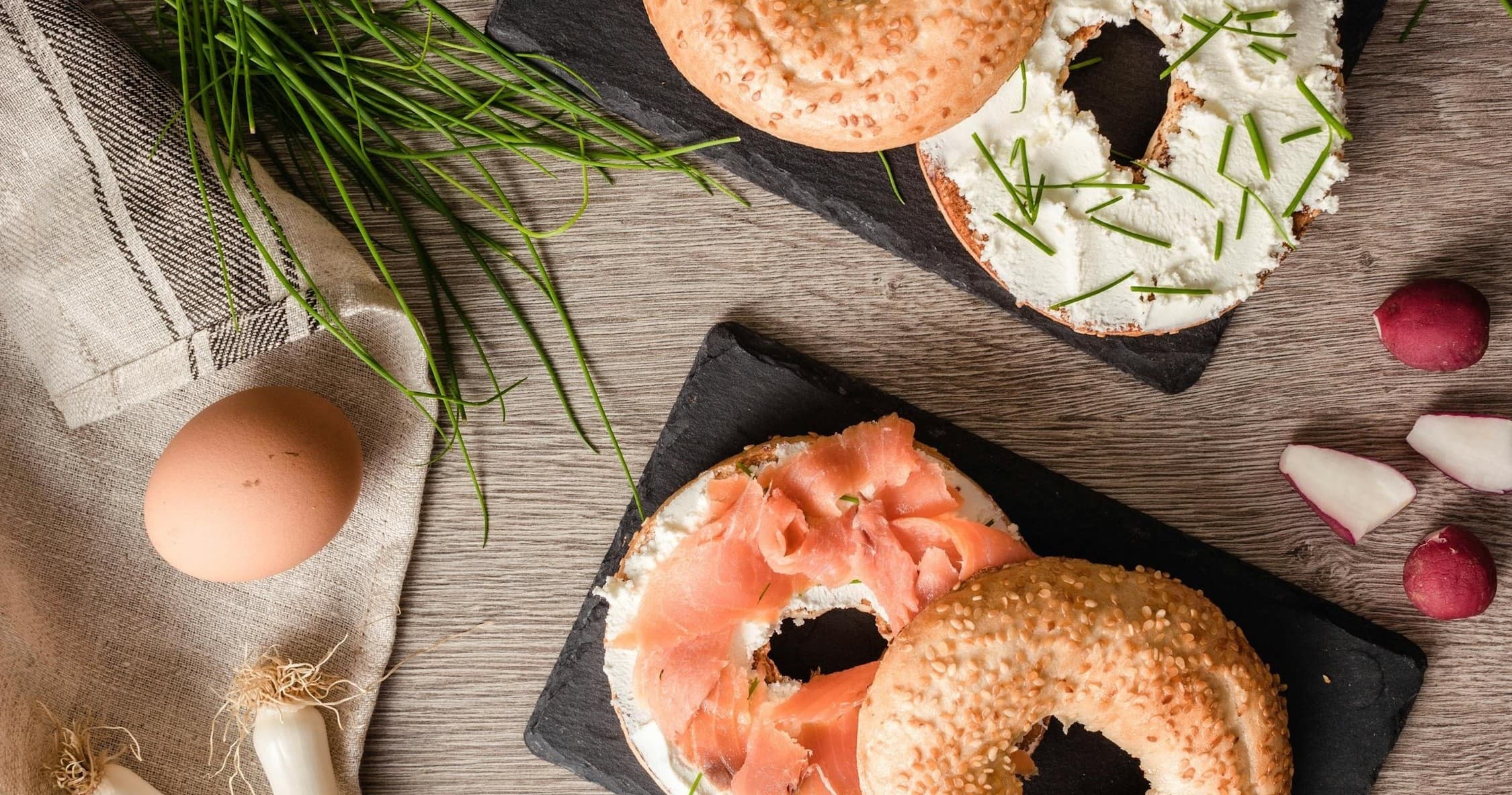 Assorted bagels and toppings on board, cafe breakfast spread