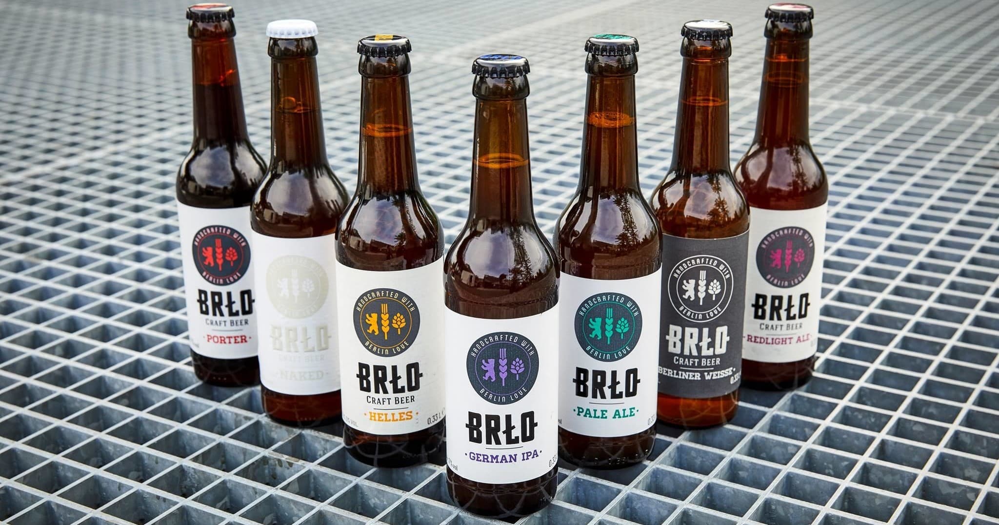 Assorted BRLO beer bottles arranged outdoors on metal grate