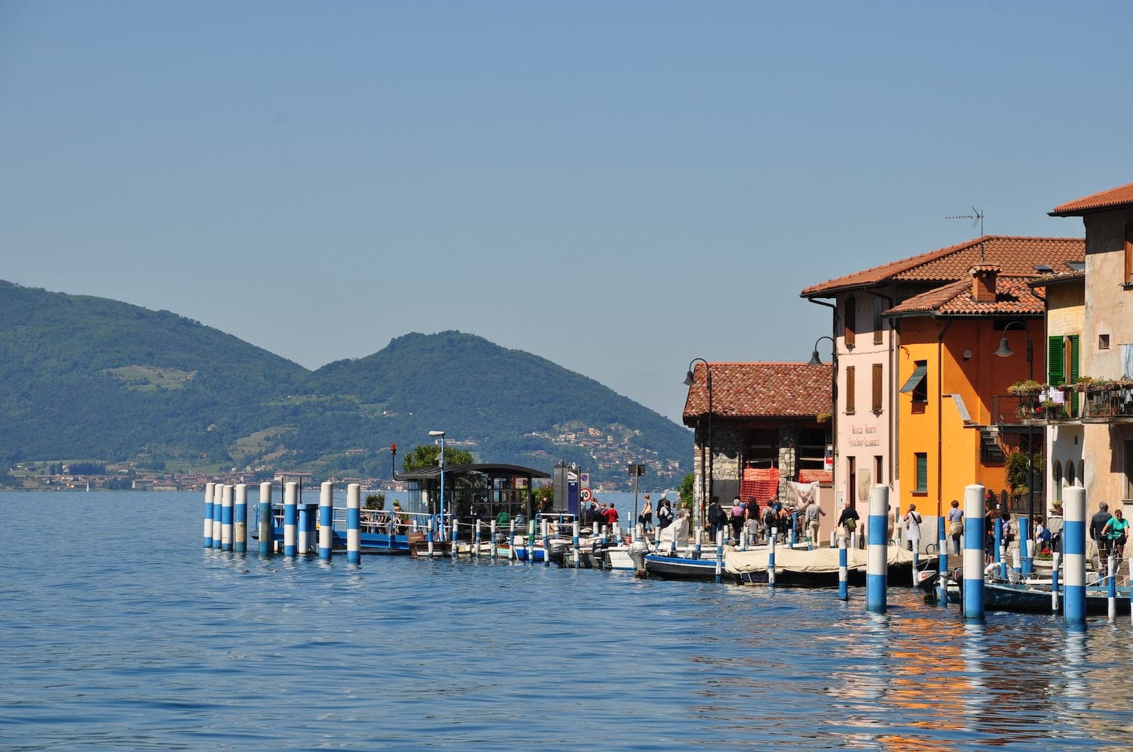 Colorful lakeside pier and promenade with mountain backdrop
