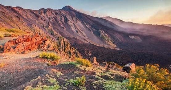 Colorful volcanic crater ridge at sunset showcasing rugged terrain