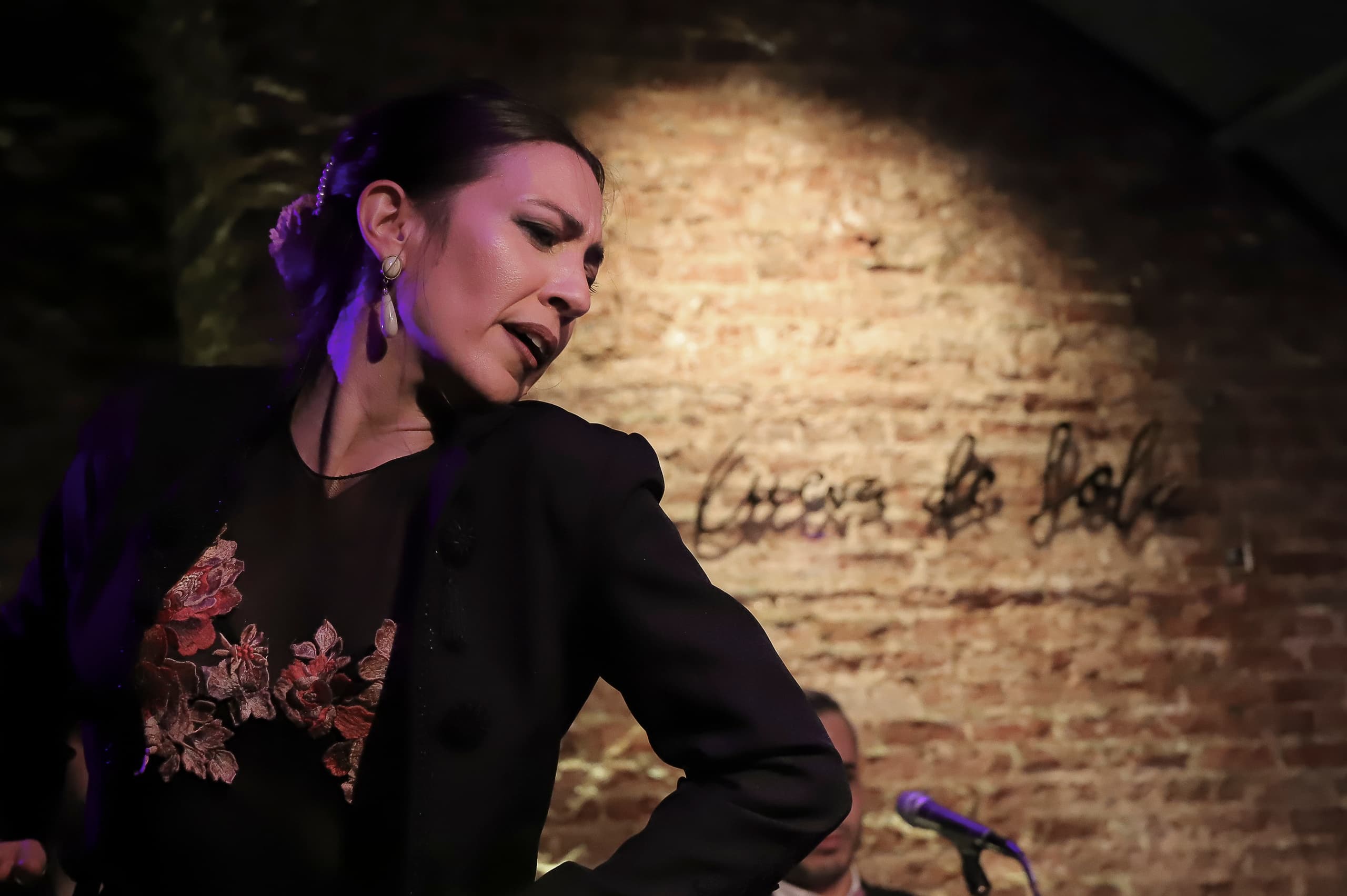 Portrait of female flamenco performer by brick wall in cave venue