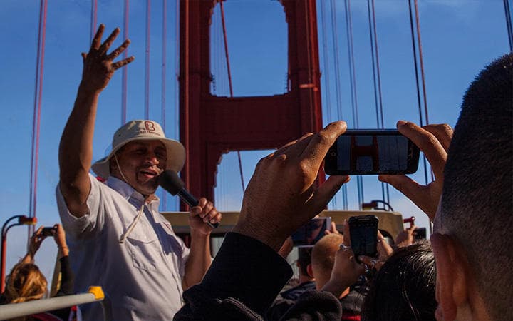 Tourists photographing Golden Gate Bridge from bridge walkway in San Francisco
