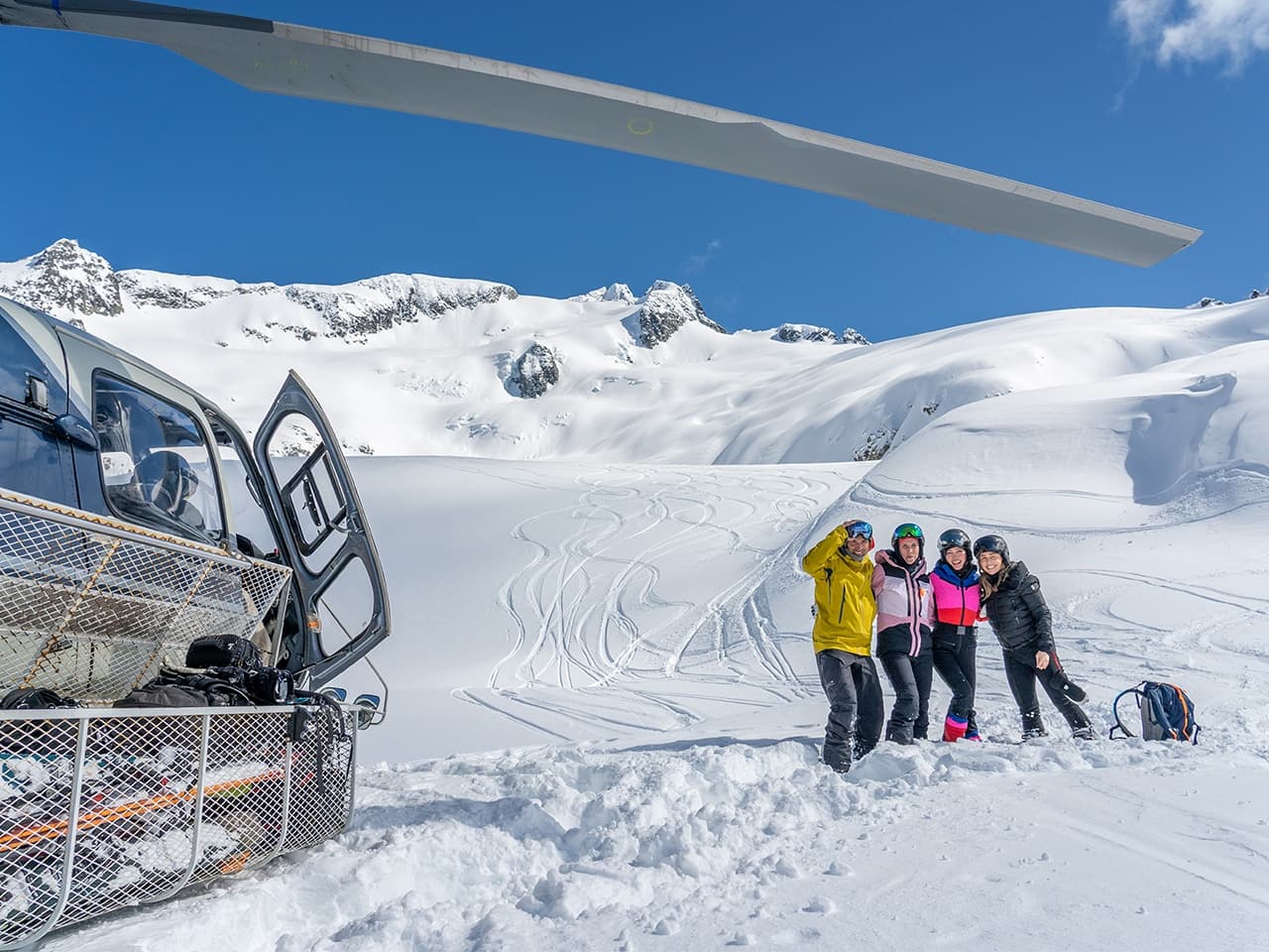 Heli-skiers gathered near helicopter on remote glacier