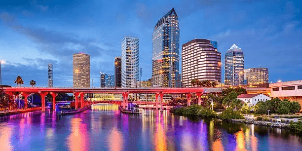 Colorful riverside city skyline with illuminated bridge reflection