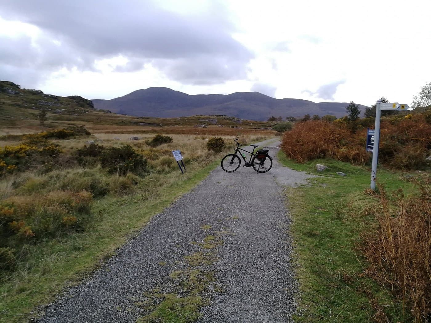 Bicycle on gravel trail with hills and cloudy sky in Killarney
