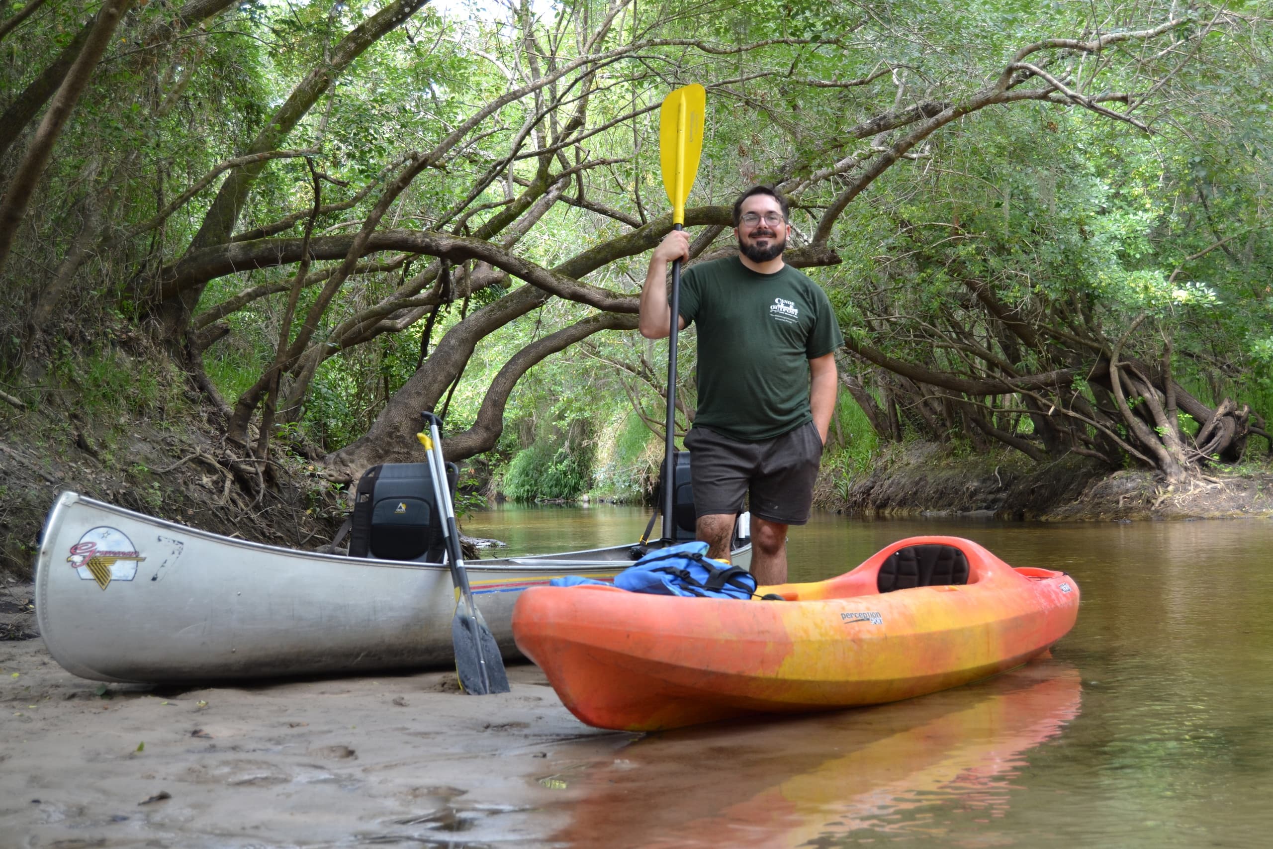 Canoeing and kayaking on shaded river under tree canopy