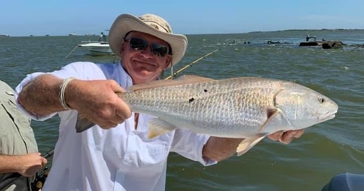 Angler displaying redfish aboard Galveston inshore fishing trip