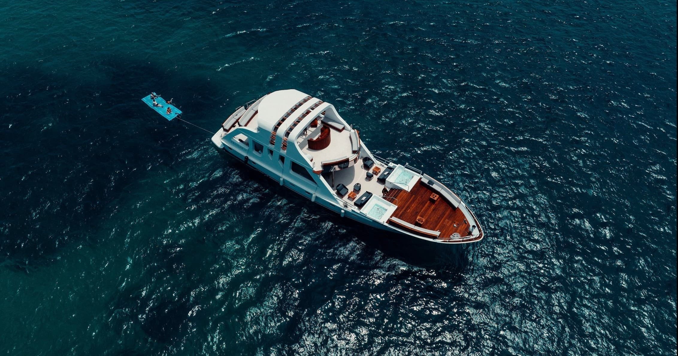 Aerial solitary yacht cruising deep blue ocean off Cabo