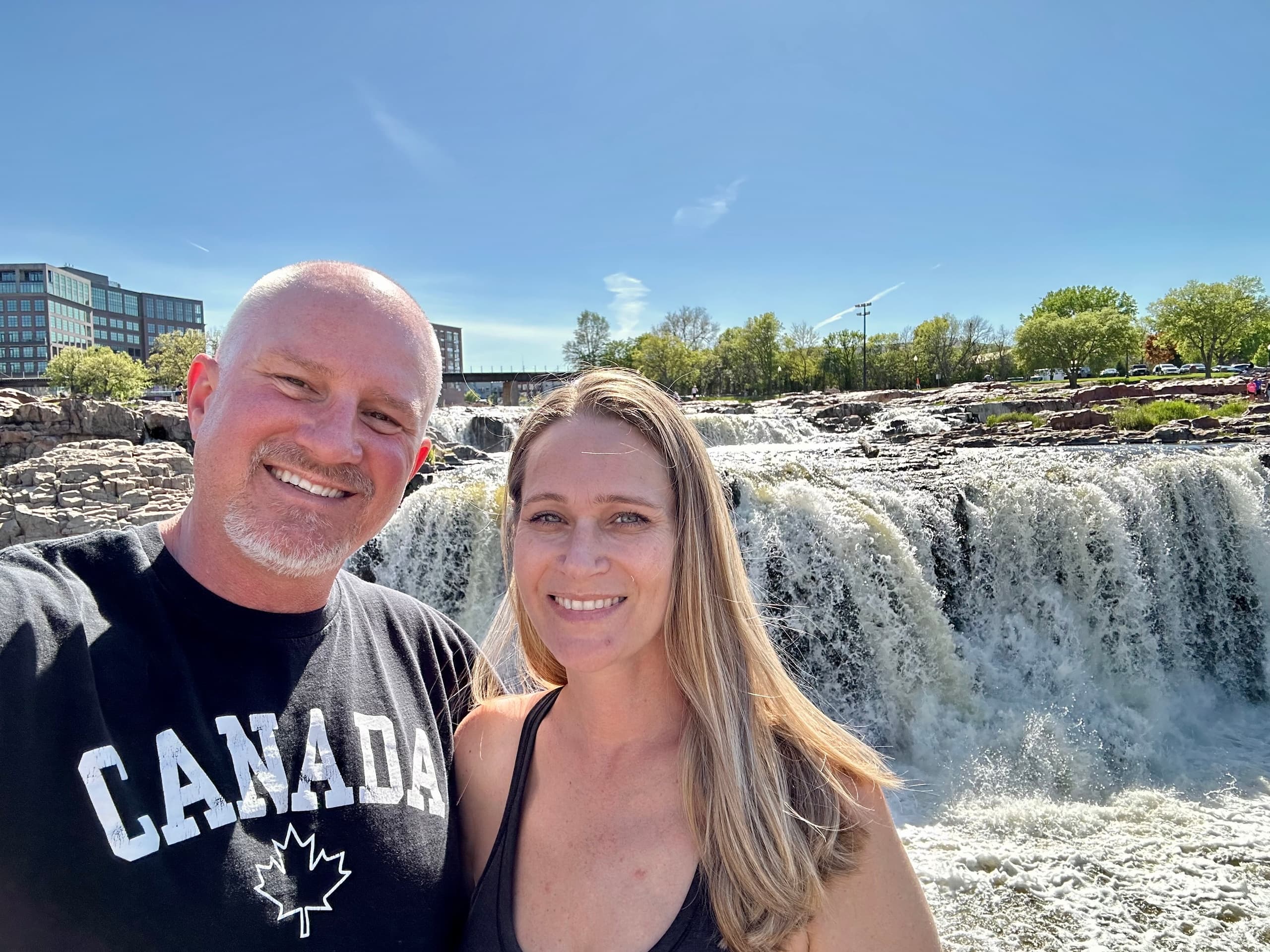 Smiling couple at waterfall after kayaking on scenic river