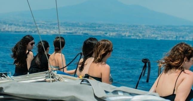 Group sailing trip on coastal waters, passengers enjoying view