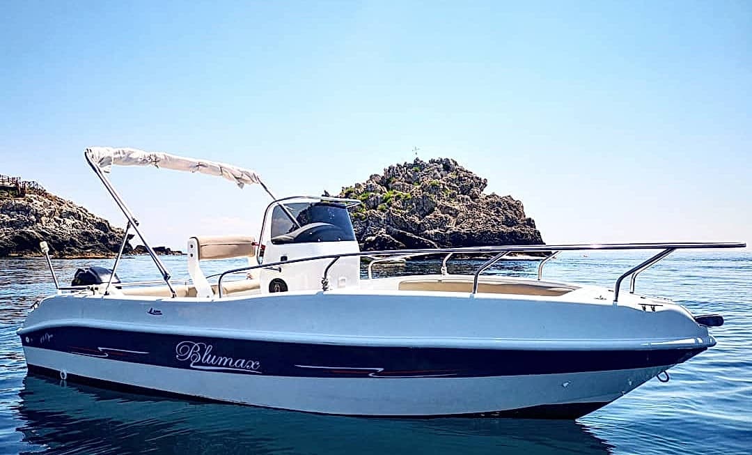 Motorboat moored near rocky Taormina islet for island tours
