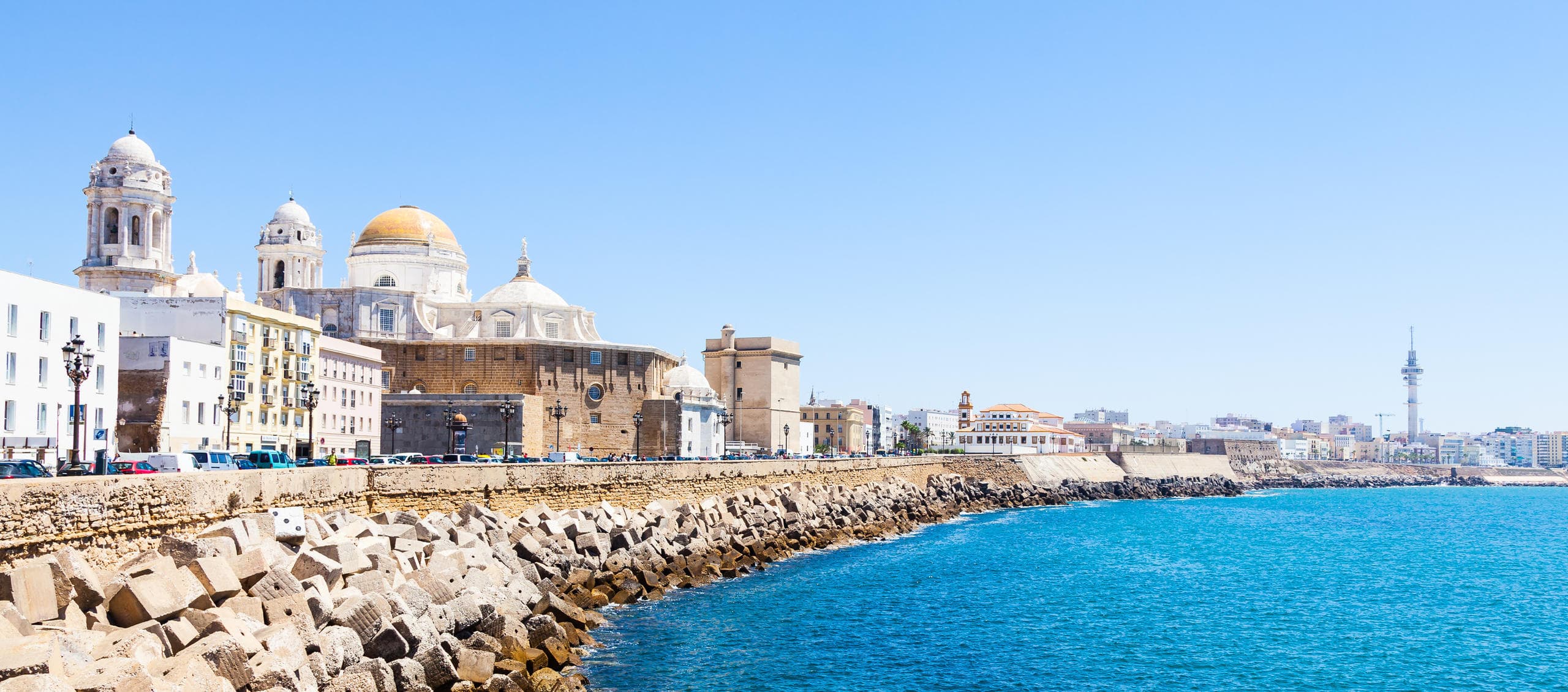 Cadiz seaside promenade with cathedral along turquoise coast