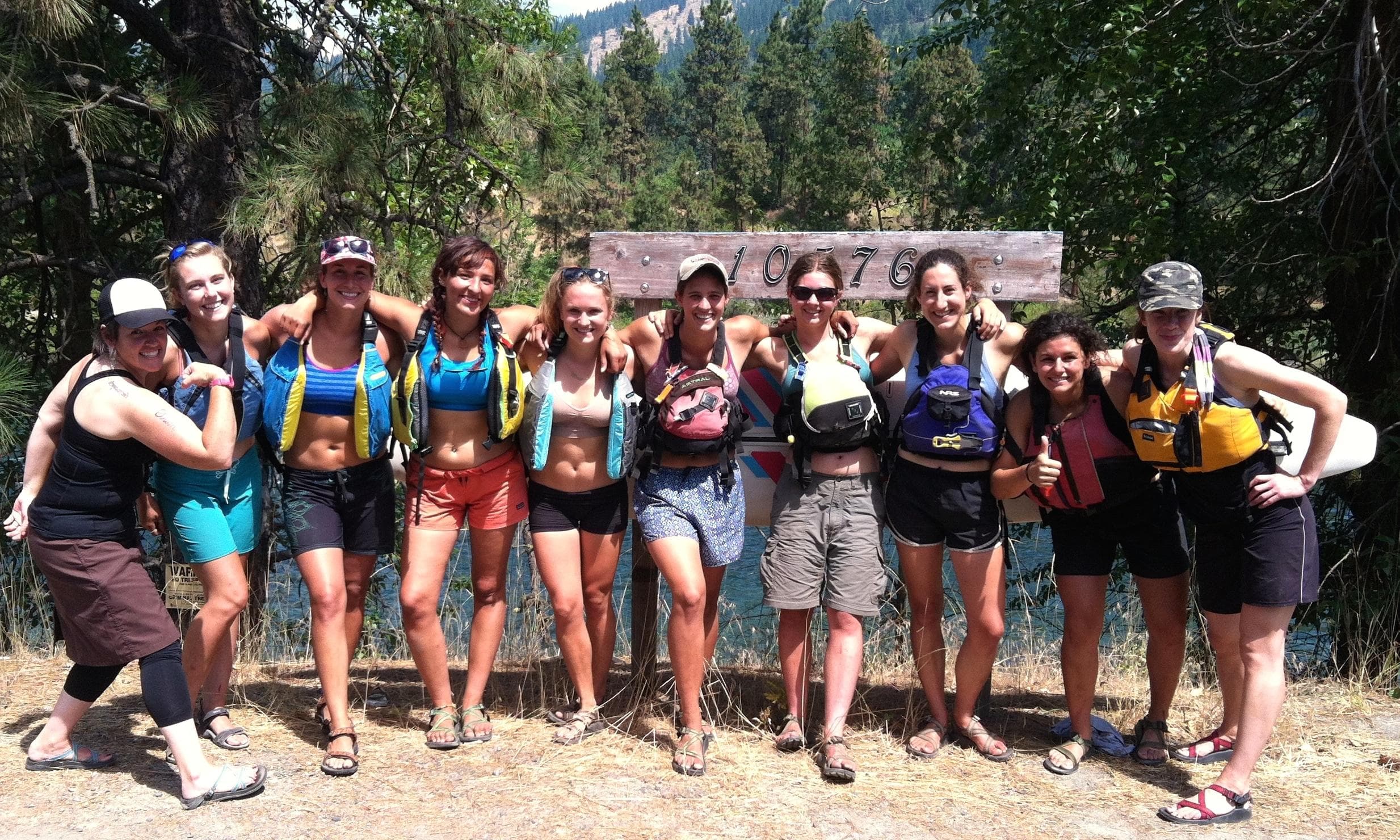 Outdoor guide team posing at scenic trailhead in forested canyon