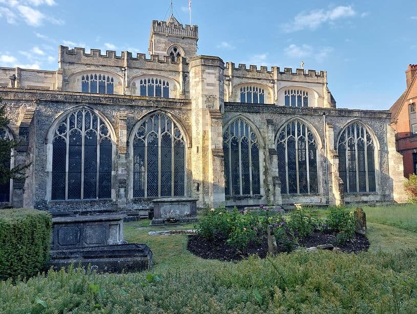 Historic stone church exterior and graveyard garden at sunset