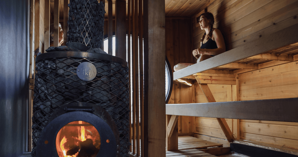 Wood-fired sauna stove with stacked stones and wooden benches