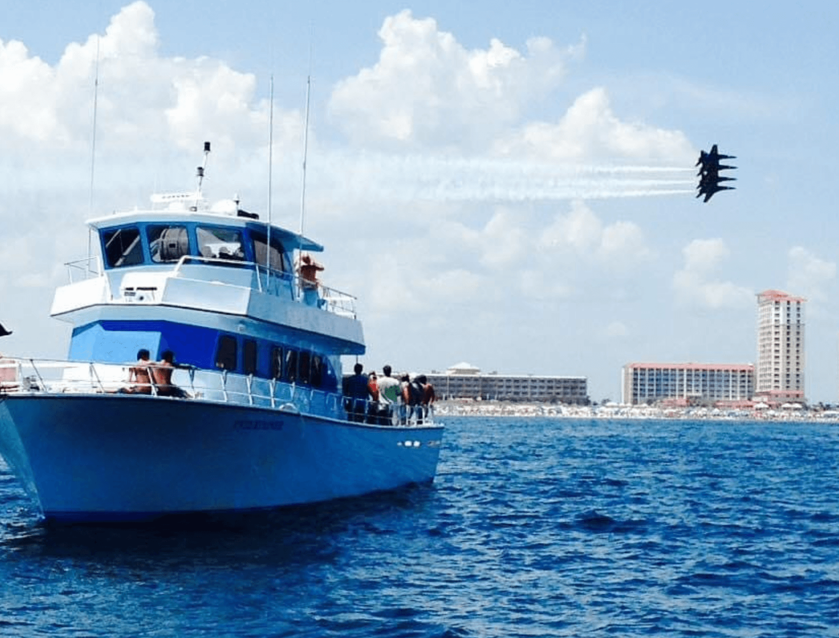 Passenger boat on open sea with flyover jet demonstration